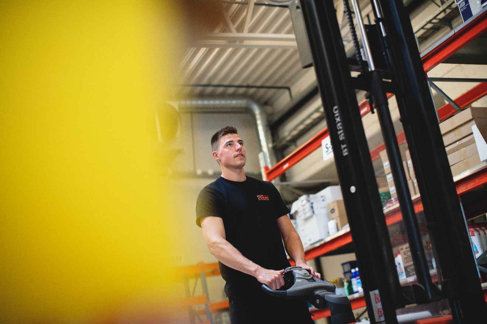 Truckfører flytter paller inne i et distribusjonslager