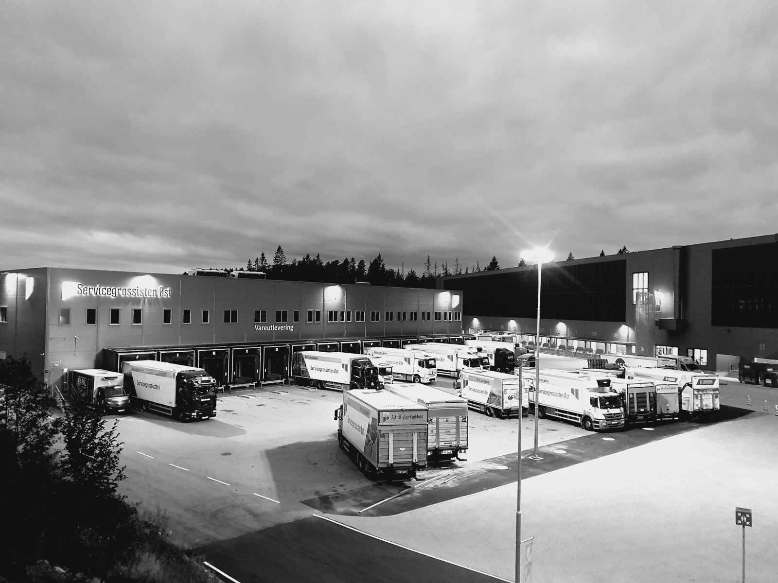Fugleperspektiv av et distribusjonsområde med rader av trailere i skumringen