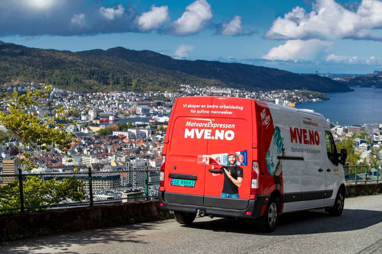 Varebil som kjører gjennom en norsk fjordby